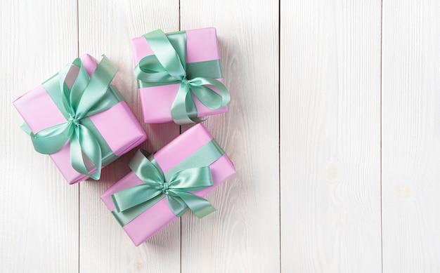 Tres cajas de regalo rosas sobre un fondo claro El concepto de vacaciones