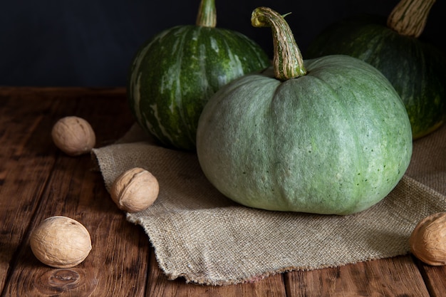 Tres calabazas verdes en un oscuro