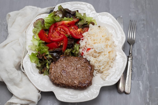 Tres carnes molidas fritas con ensalada fresca en un plato blanco