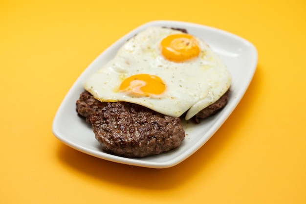 Tres carnes molidas fritas con huevo frito en manjar blanco