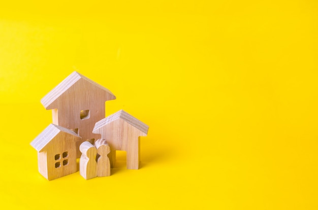 Três casas em um fundo amarelo. Compra e venda de imóveis, construção.