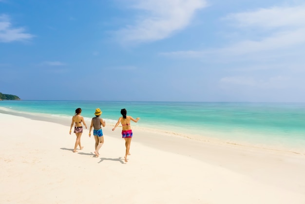 Tres chicas con bikini caminando en la playa