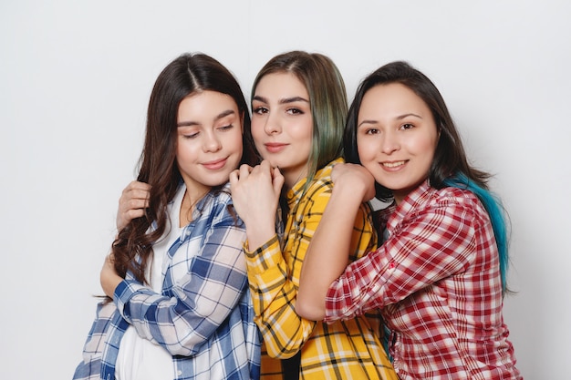 Tres chicas con estilo mejores amigas. Parados juntos y divirtiéndose.