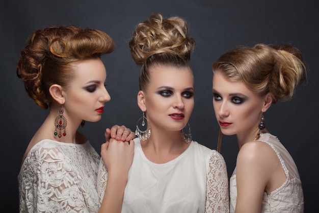 Tres chicas con un estilo retro elegante y destartalado y vestidos blancos con un fondo negro