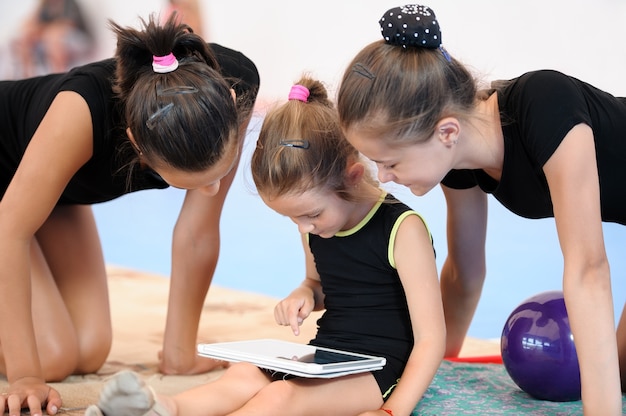 Tres chicas gimnasta con tableta