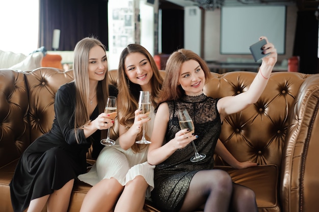 Tres chicas jóvenes están haciendo una foto selfie en un restaurante.