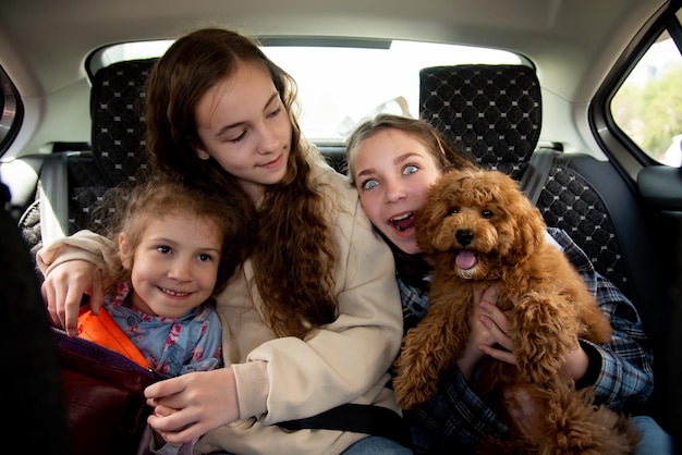 Tres chicas lindas y un perro en el auto.