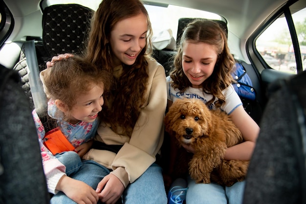 Tres chicas lindas y un perro en el auto.