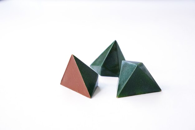 Tres chocolates de color verde y diseño de caramelo triangular geométrico