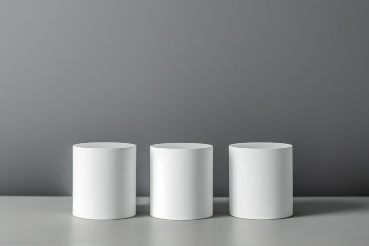 Tres cilindros blancos sobre un fondo gris Maqueta para el diseño