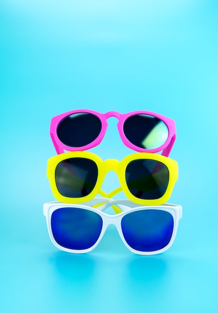 Três, colorido, óculos de sol, em, luz, azul, estúdio, fundo
