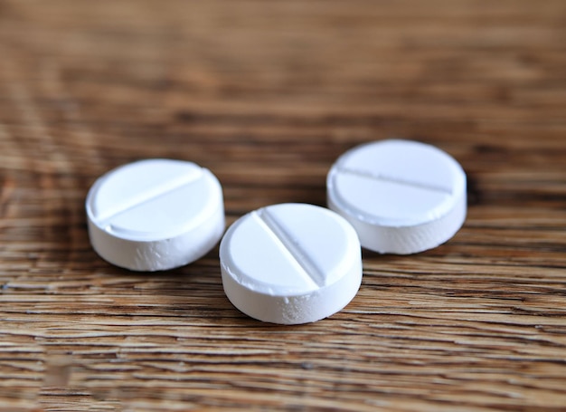 Três comprimidos em uma mesa, um dos quais é rotulado como 'pílula'