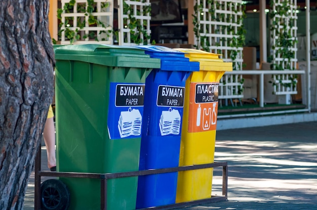 Tres contenedores de reciclaje para vidrio, plástico y papel en una calle de la ciudad