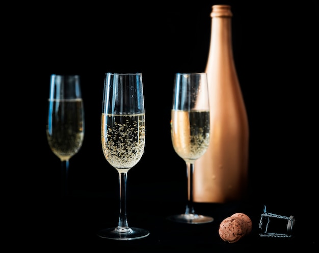 Foto tres copas de champagne con botella