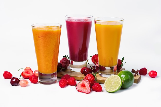 Três copos com smoothies de frutas no fundo branco