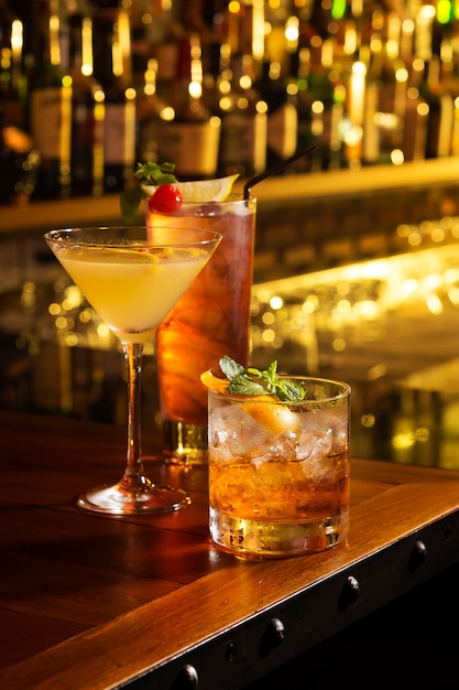 Foto três copos de cocktail servem na mesa de bar
