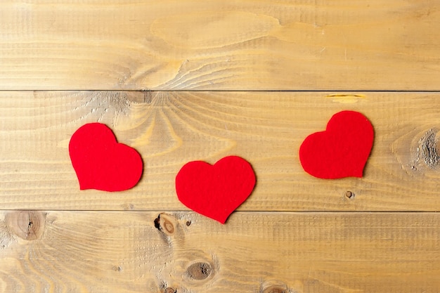 Tres corazones en el fondo de madera corazones rojos en madera vieja gris