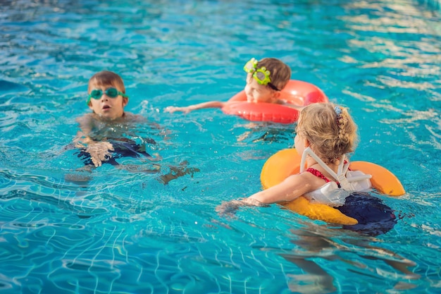 Três crianças brincando na piscina