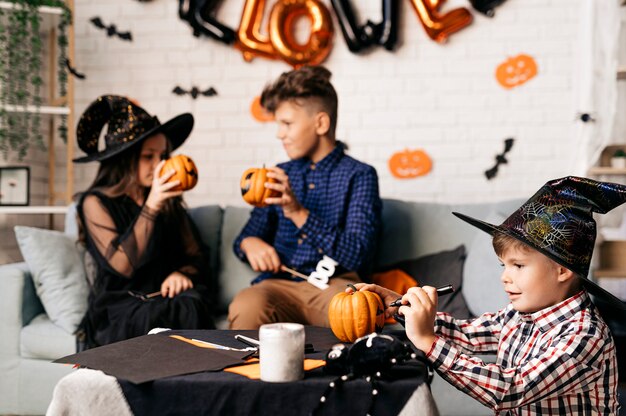 três crianças em uma festa de halloween