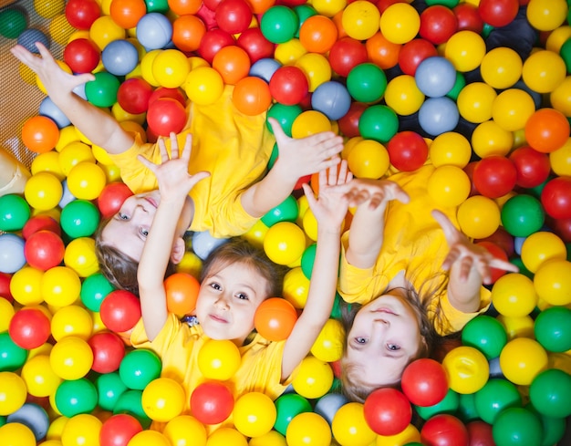 Três crianças felizes na piscina sorrindo