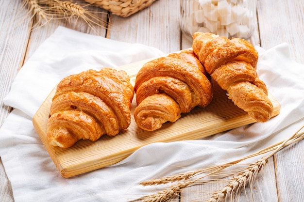 Três croissants franceses na tábua de madeira