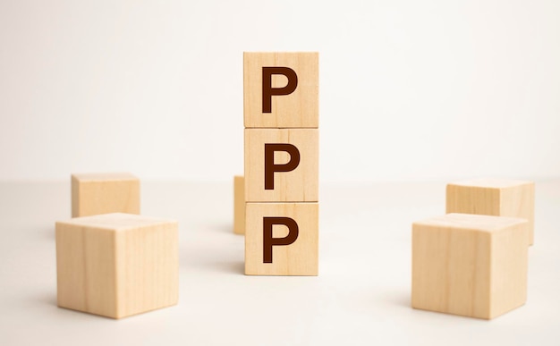 Três cubos de madeira com letras PPP significa Praise Picture Push na mesa branca