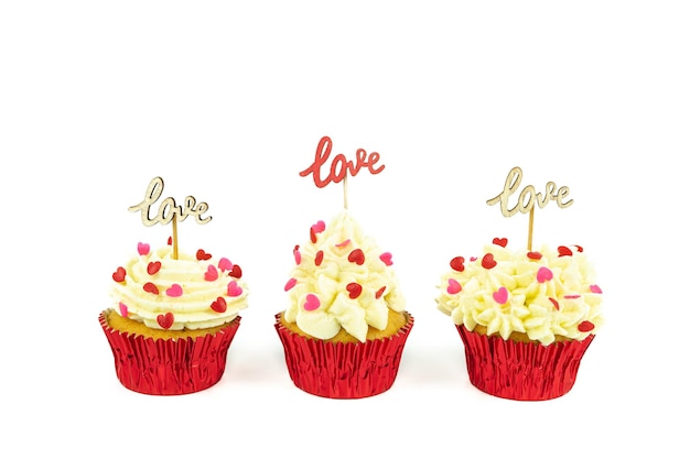 Tres cupcakes decorados con motivos rojos sobre fondo blanco con carteles de madera con la palabra AMOR. Día de San Valentín.