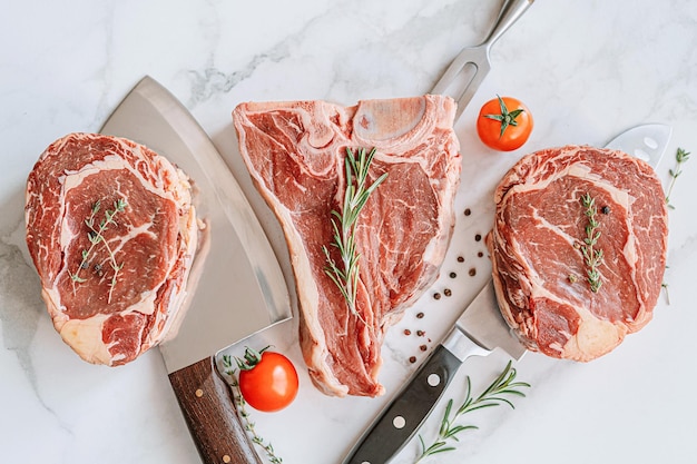 Três deliciosos bifes prontos para grelhar em uma superfície de mármore branco