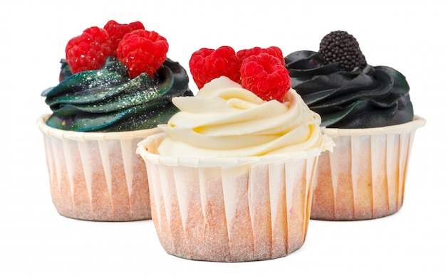 Foto tres deliciosos cupcakes con cobertura de crema aislado en blanco