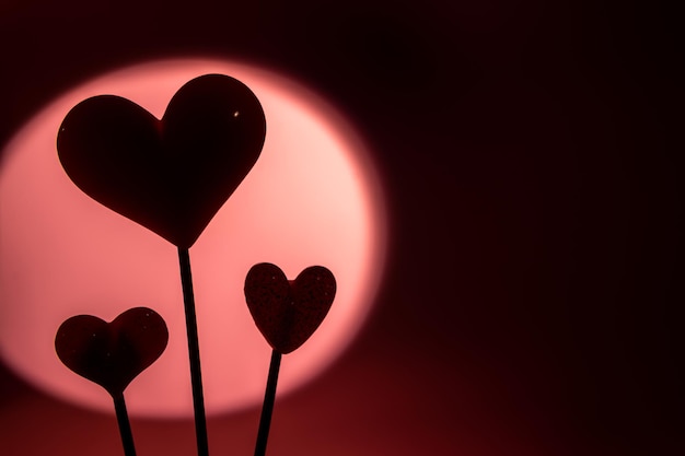 Três doces de pirulito em formato de coração rosa dia dos namorados em fundo de papel pastel vazio conceito de amor