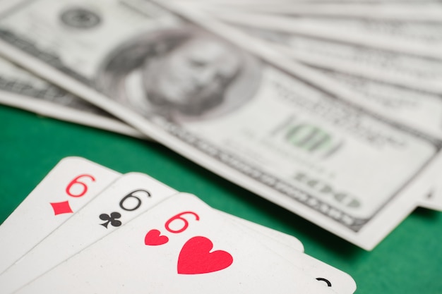 Três dos seis durante o pôquer com dólares na mesa verde.