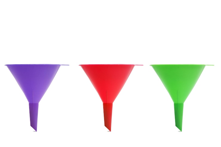 Foto tres embudos de colores aislado sobre un fondo blanco.