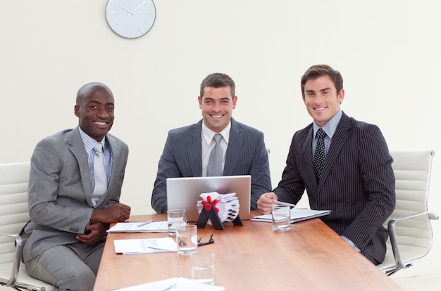 Três empresários em uma reunião sorrindo