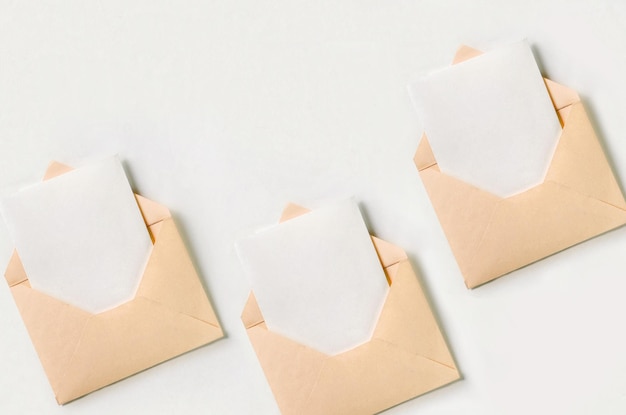 Três envelope laranja claro aberto com folha de papel