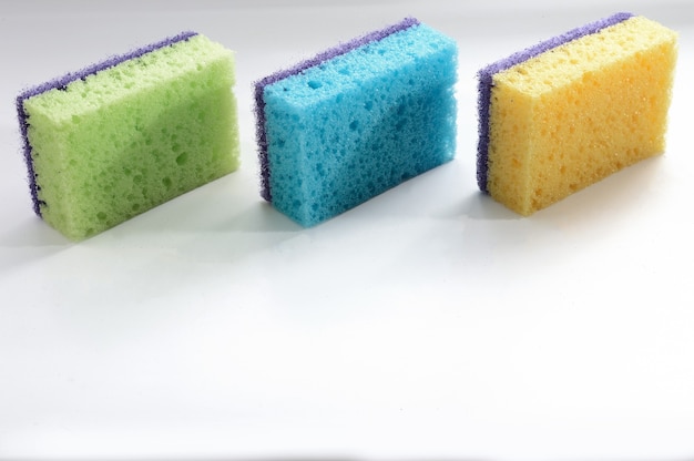 Foto três esponjas multicoloridas para lavar pratos