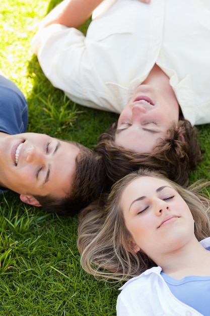 Três estudantes felizes descansando juntos