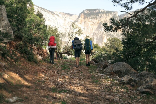 Tres excursionistas en camino en las montañas