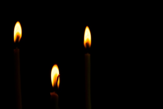 Tres formas delgadas de la luz de la vela de la paz en la oscuridad y la llama amarilla demandar como elementos de paz yoga