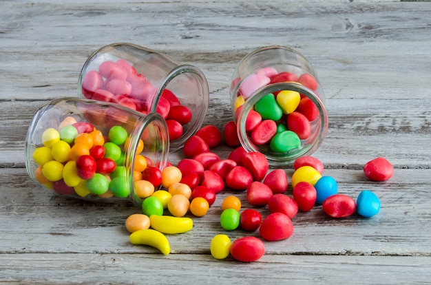 Tres frascos en la mesa con dulces dispersos