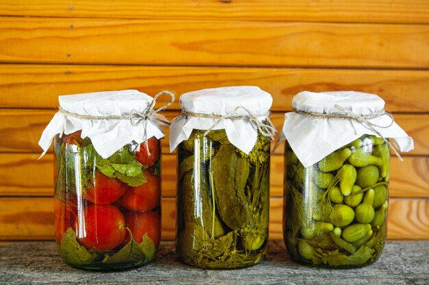 Tres frascos de vidrio de coloridas verduras encurtidas