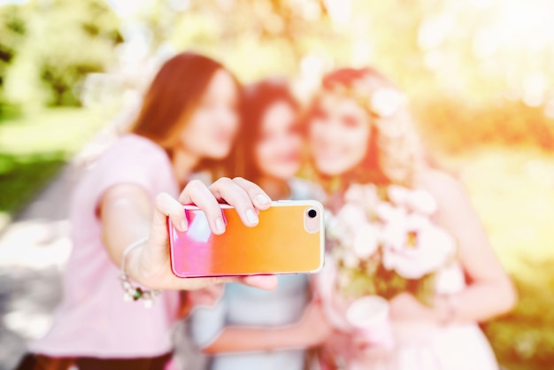 Três garotas bonitas fazendo selfie com a noiva no casamento