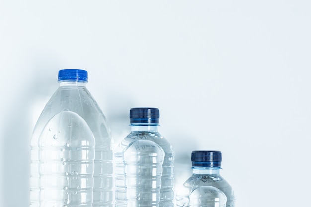 Três garrafas de plástico cheias de água mineral por cima
