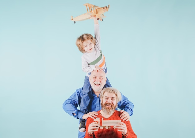 Tres generaciones diferentes edades abuelo padre e hijo hijo jugando con avión de juguete en estudio i