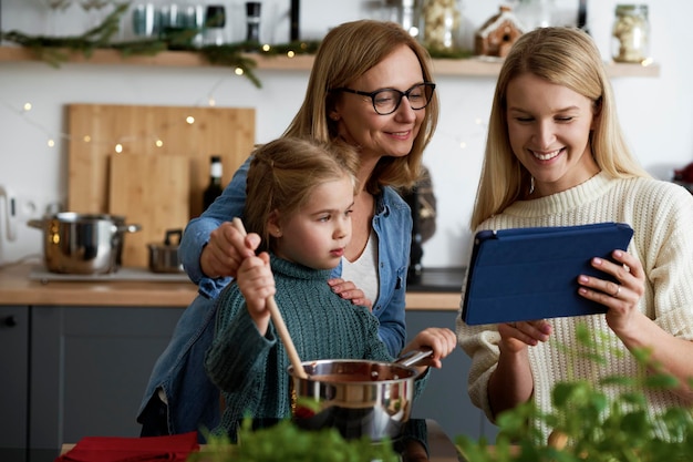 Tres generaciones de mujeres buscando recetas en la tablet