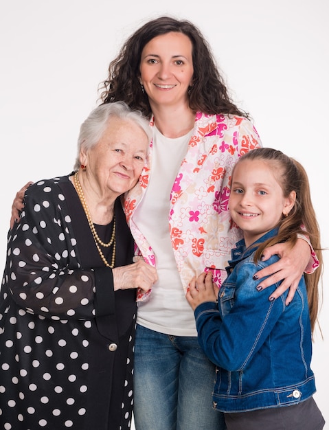 Tres generaciones de mujeres en una pared blanca