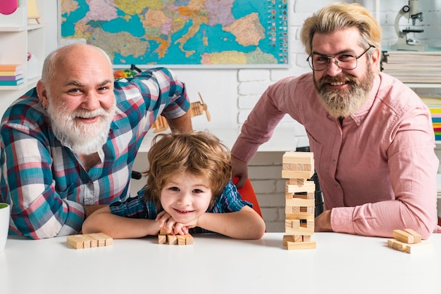 Três gerações de homens ativos jogando jenga na sala de estar em casa