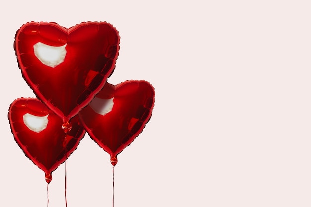 Tres globos de aire rojo en forma de corazón sobre una superficie clara