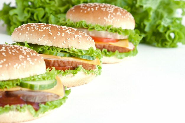 Tres hamburguesas con carne y verduras.