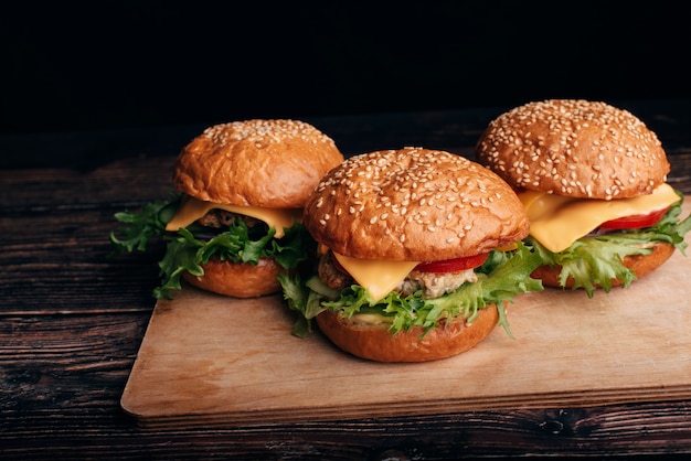 Tres hamburguesas caseras con carne, queso, lechuga y tomate.