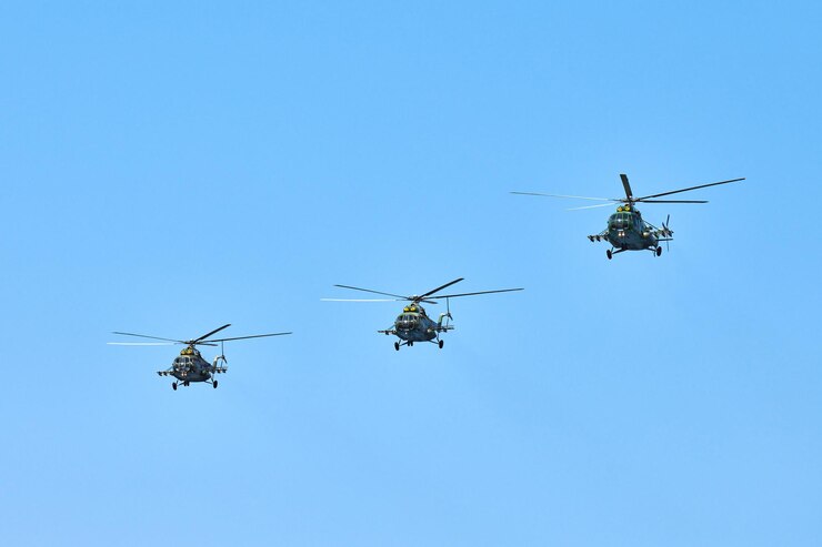 Foto três helicópteros militares voando no céu azul brilhante durante o voo de demonstração, copie o espaço. equipe acrobática realiza vôo em show aéreo